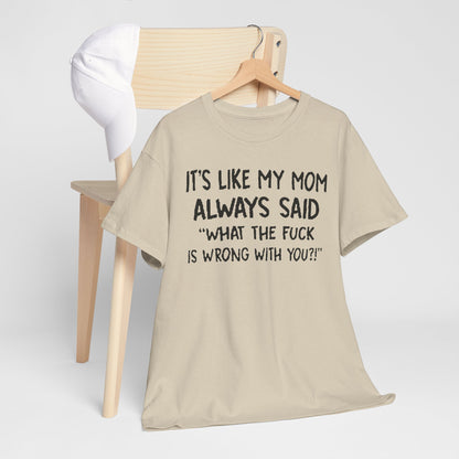 Stylish presentation of the Funny Mom Quote T-Shirt draped elegantly on a wooden chair with a cap, featuring the quote 'It's Like My Mom Always Said: What the F*** Is Wrong with You?!'.