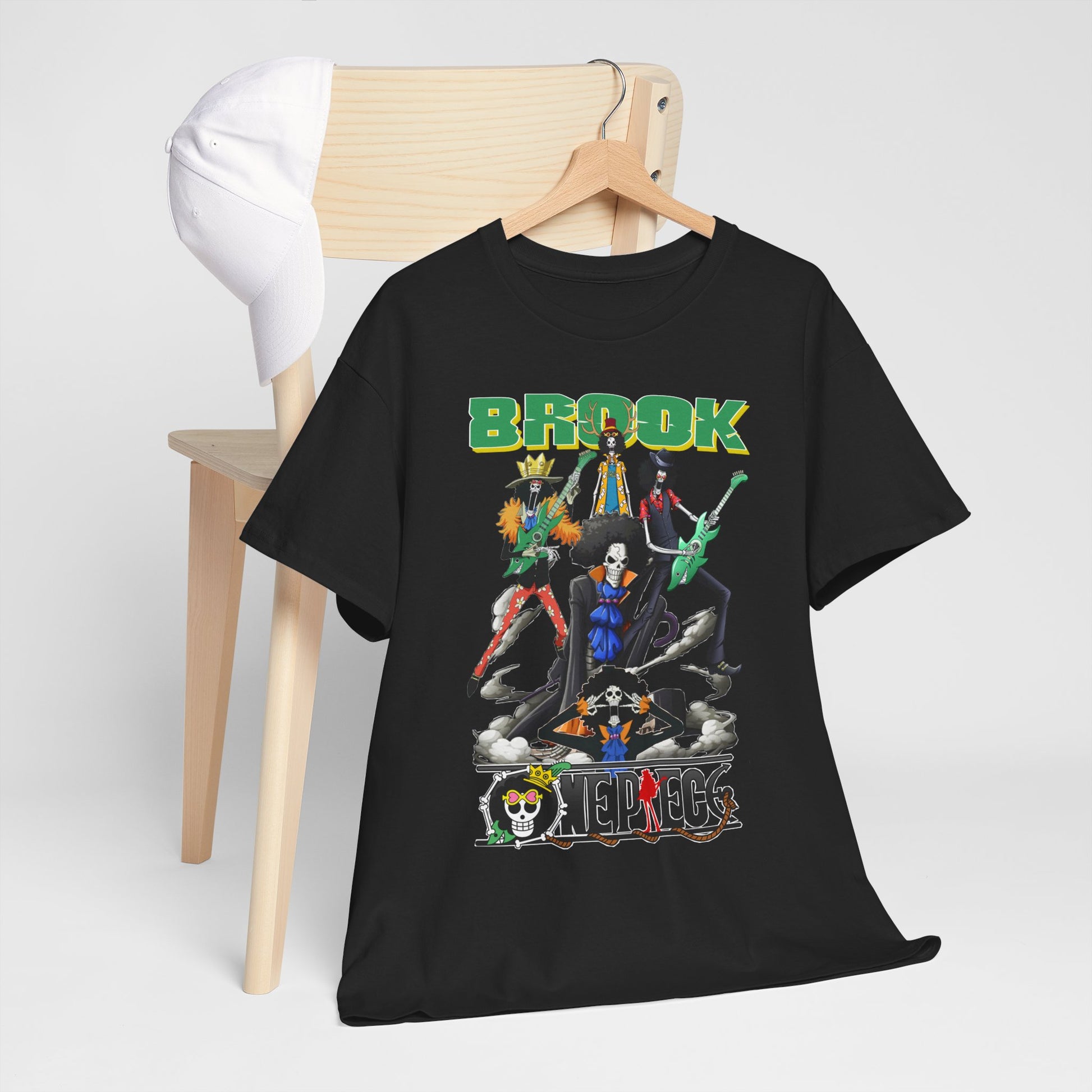 Stylish black men's t-shirt featuring vibrant anime characters in a rock band pose, hanging on a wooden chair with a white cap, designed for adventure enthusiasts.