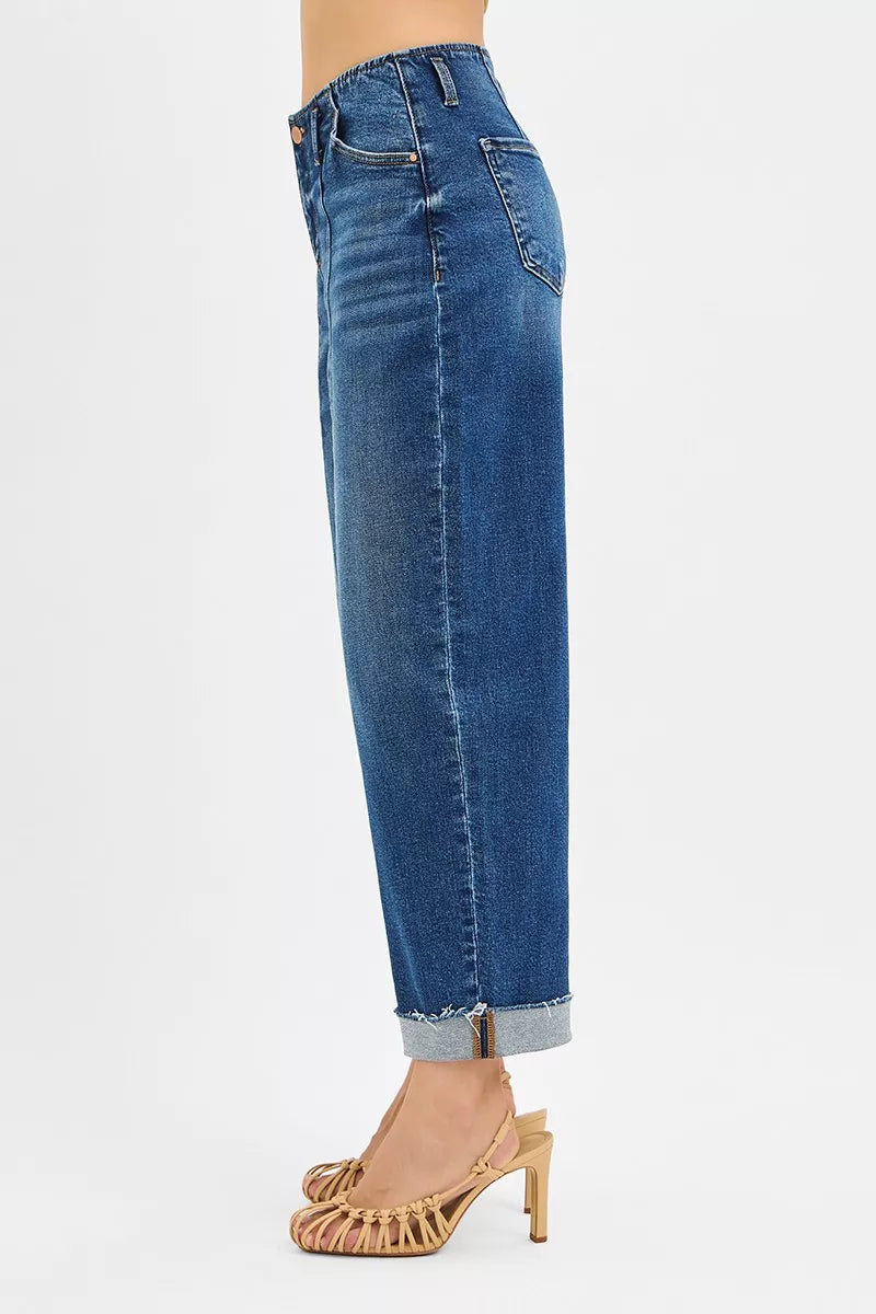 Side perspective of high rise cuffed jeans, displaying their flattering fall and fashionable cuff effect, perfect for contemporary wardrobe styling.