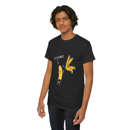 Male model showcasing a premium black t-shirt featuring a fun cartoon banana graphic and the statement 'LET'S GET NAKED!', blending humour with high-end street style.