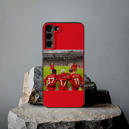 Luxury Manchester United Mainoo Garnach Hojlund Soft Phone Case displayed on stone, featuring a vibrant design with team players celebrating on a football pitch.