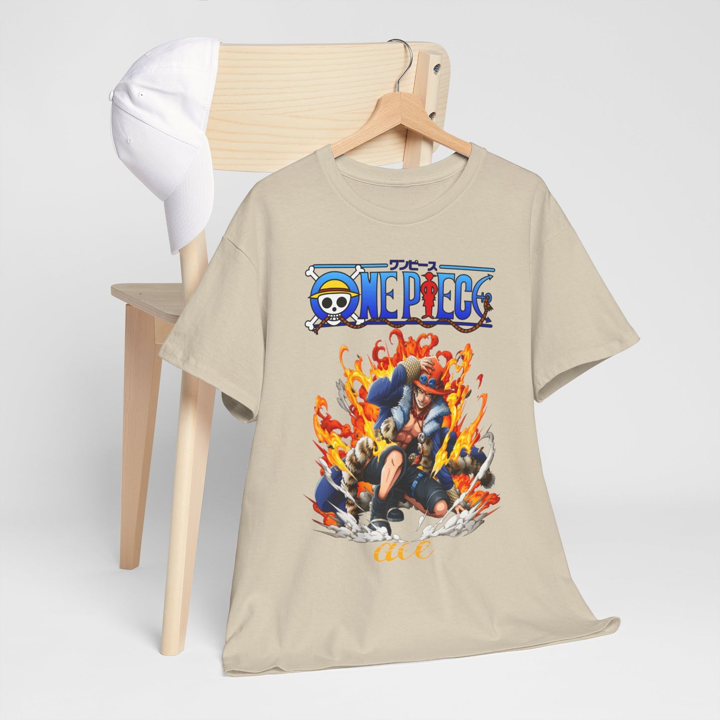 Luxury men's beige T-shirt featuring a vibrant anime design of Ace from One Piece, surrounded by dynamic flames, elegantly displayed on a wooden hanger with a white cap in a minimalistic setup.