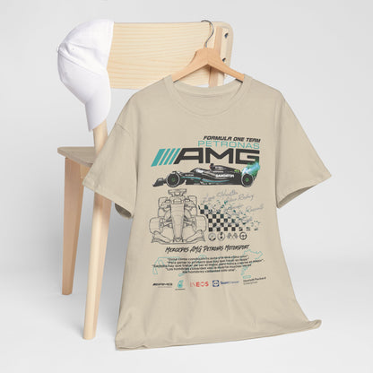 Stylish F1 Mercedes AMG Petronas T-Shirt displayed on a chair alongside a white cap, featuring intricate race car artwork and elegant typography.