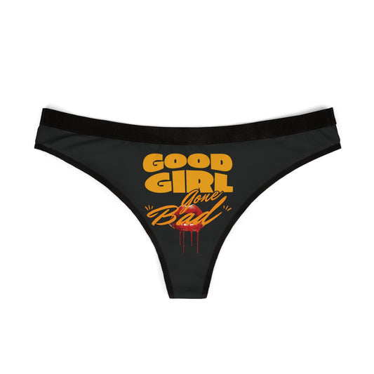 Luxurious women's thong featuring 'Good Girl Gone Bad' graphic design in vibrant orange on elegant black fabric, showcasing a cheeky aesthetic.