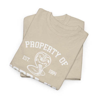 Elegant flat lay of a luxurious Cobra Kai T-shirt, showcasing the prominent graphic logo and impeccable fabric quality in a stylish beige tone.