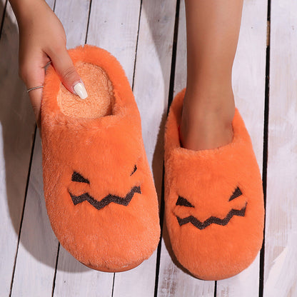 Cute Halloween Pumpkin Slippers displayed in a hand, highlighting the luxurious coral velvet and whimsical pumpkin design, making them perfect for adding festive flair to your indoor wardrobe.