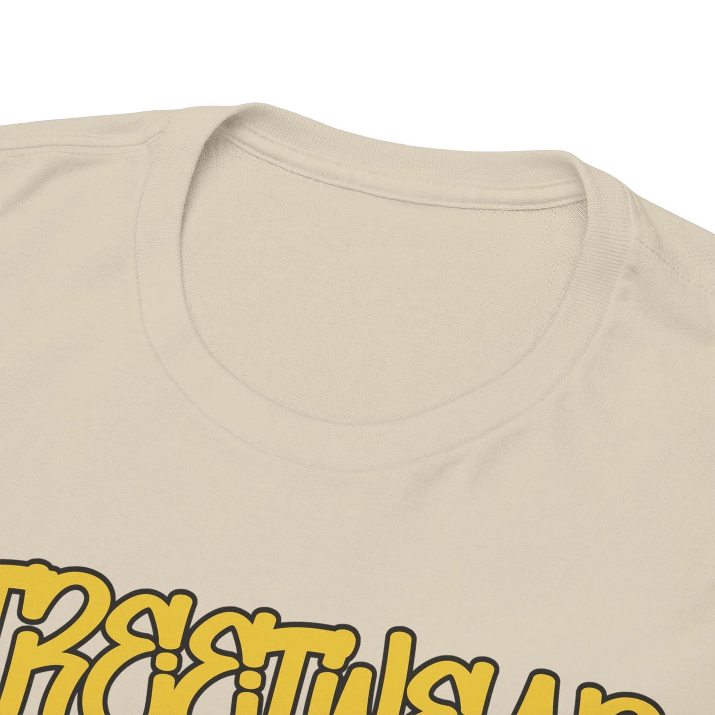 Close-up view of the neckline and intricate design details of a luxurious beige t-shirt, featuring striking yellow text and unique artwork.