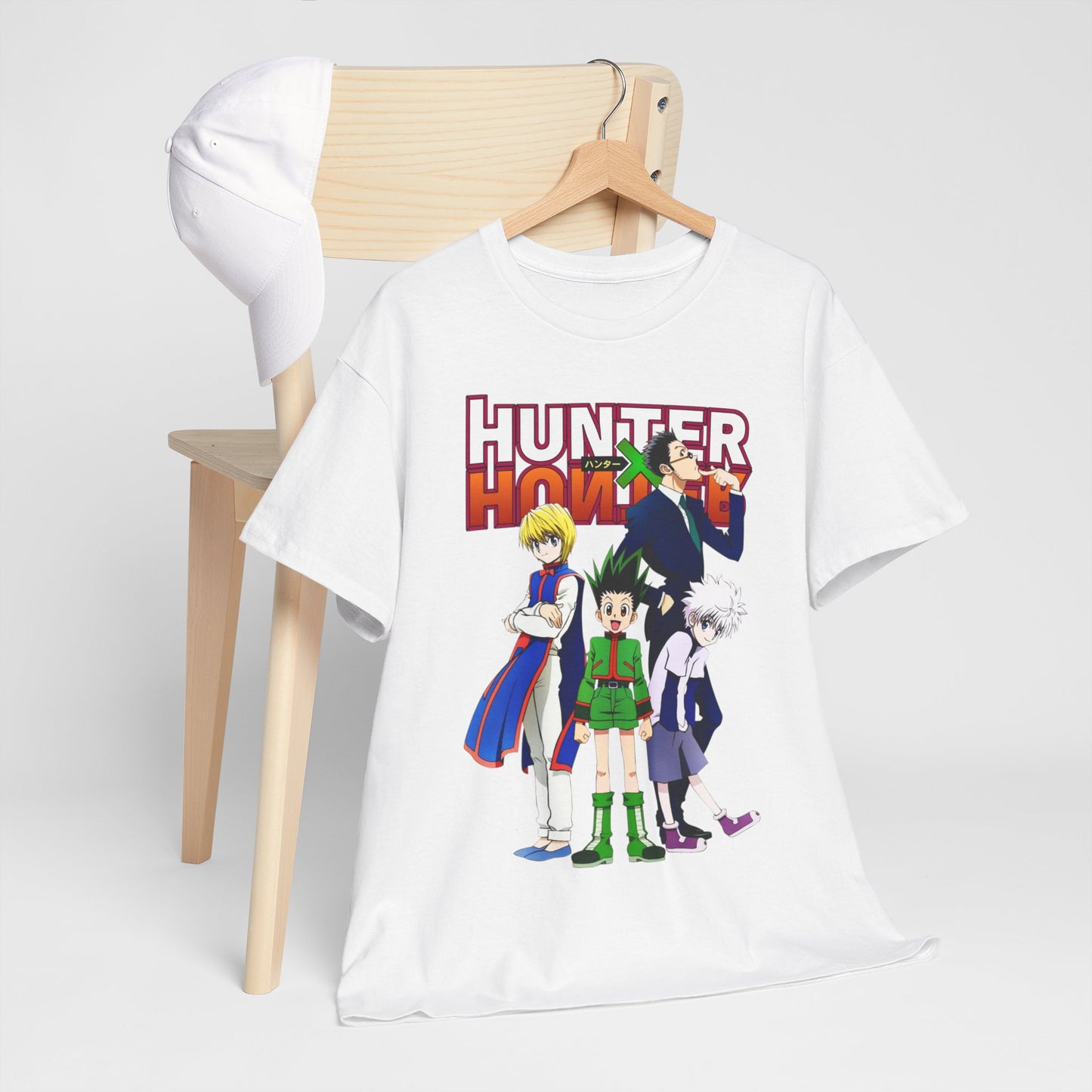 Chic Hunter x Hunter T-Shirt laid on a chair next to a cap, highlighting a vivid illustration of beloved characters, perfect for any casual wardrobe.