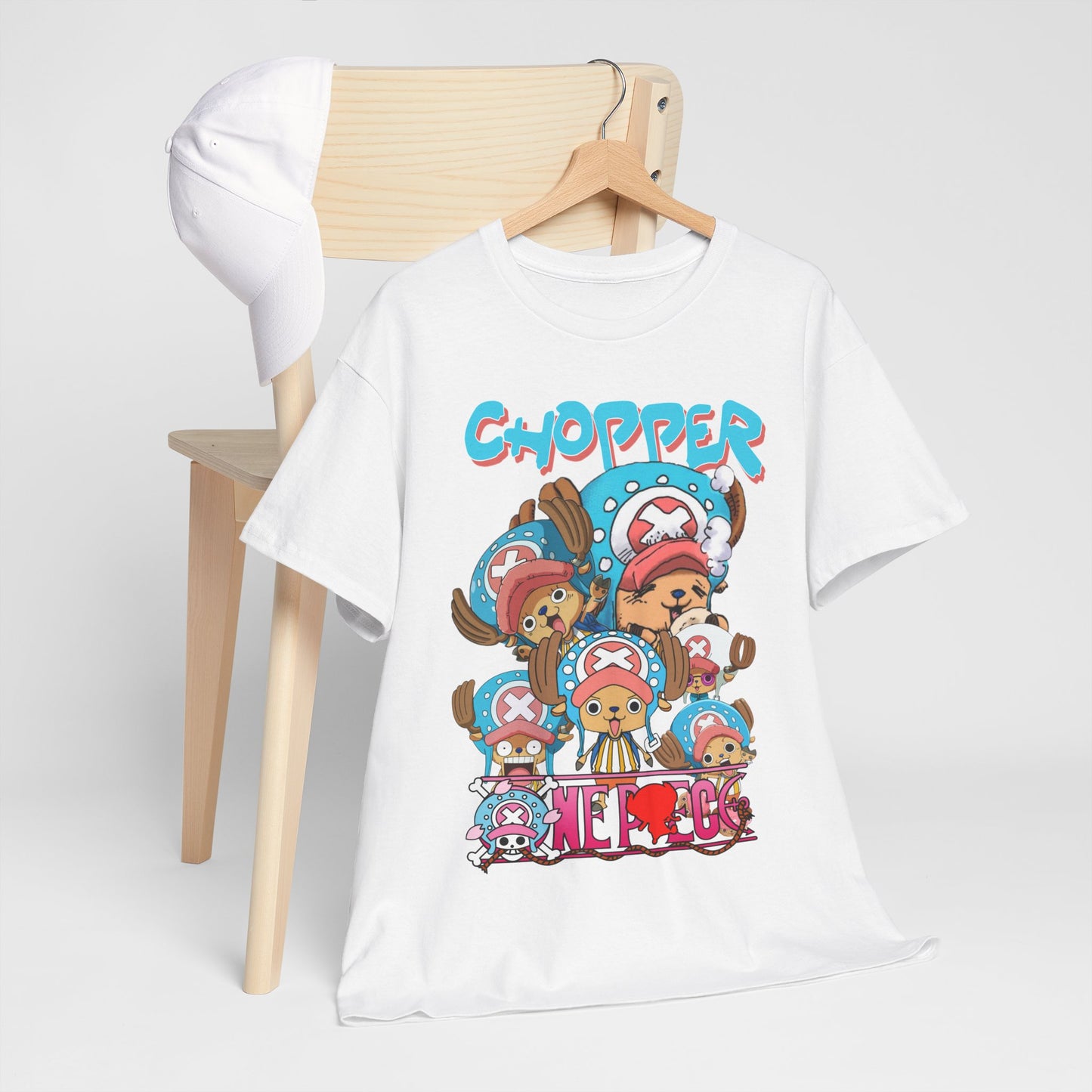 Stylish white t-shirt featuring vibrant graphic designs of Chopper from anime, showcasing his fun expressions, on a wooden hanger next to a white cap.