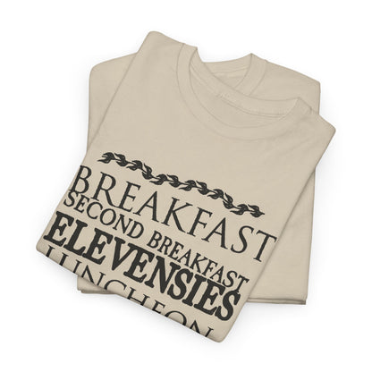 Sophisticated pair of beige t-shirts folded neatly, each adorned with a unique design of hobbit meal names from the Lord of the Rings, embodying a blend of humour and elegance.