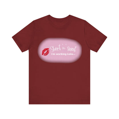 Sabrina Carpenter Inspired Unisex Short Sleeve Tee with Vibrant Lipstick Print in rich maroon, elegantly displaying the slogan 'Short 'n' sweet, I'm working Late...' perfect for fashion enthusiasts.