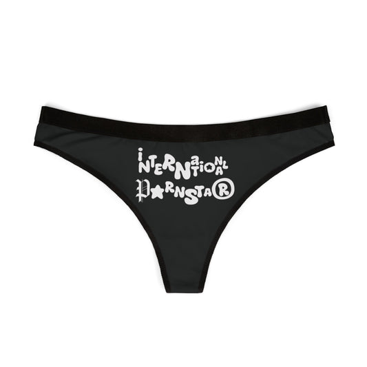 Elegant black thong featuring playful white graphic design stating 'INTERNATIONAL Pornstar®'. Perfect for a cheeky addition to your lingerie collection.