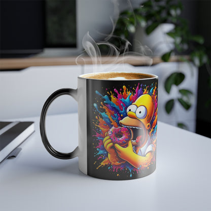 Homer Simpson 11oz Colour Morphing Mug showcasing vibrant heat-activated design with Homer holding a pink frosted donut, surrounded by playful splashes of colour, perfect for discerning Simpsons fans.