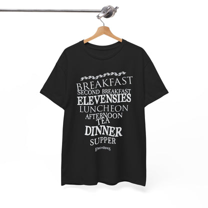 Refined black graphic t-shirt elegantly hung, featuring a charming list of hobbit meal times in white, representing the spirit of feasting from Lord of the Rings.