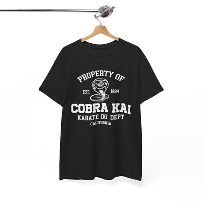 Elegantly displayed black Cobra Kai T-shirt hanging on a stylish rack, showcasing the brand's emblem and text: 'Property of Cobra Kai, Karate Do Dept, California'.