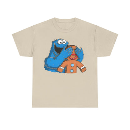 Luxury unisex Cookie Monster guess who graphic tee shirt featuring a whimsical design of Cookie Monster playfully covering the eyes of a charming gingerbread man, set against a soft, light brown fabric.