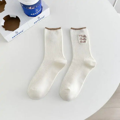 Elegant White Embroidered Socks for Women featuring a unique Japanese-style font design, displayed elegantly with a mix of cream and brown accents on a minimalistic table.