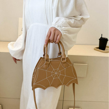 Chic khaki Halloween Spider Web Saddle Bag held by a woman, featuring exquisite spider web pattern, perfect for fashionable Halloween adventures.