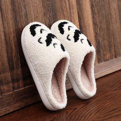 Chic Funny Bat Slipper Halloween Pumpkin Flat Indoor House Shoes, featuring a soft white exterior with bat motifs, elegantly positioned on a wooden surface.