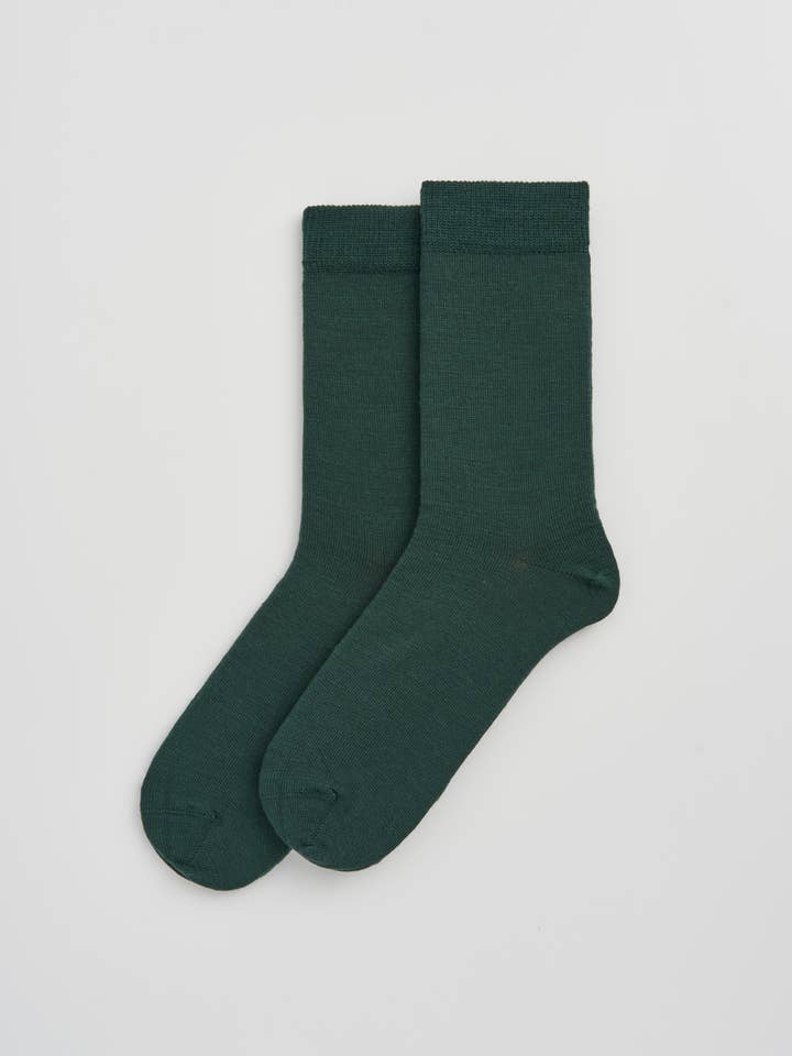 Elegant Merino Wool calf-length socks laid out, showcasing their silky finish and temperature-regulating features, ideal for all seasons.