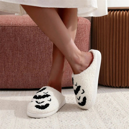 Elegant display of Funny Bat Slipper Halloween Pumpkin Flat Indoor House Shoes, featuring a white plush slipper adorned with playful bat motifs, perfect for seasonal lounging.