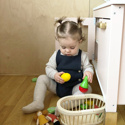 Toddler in a Stylish Baby Girl Cotton Romper engaged in play with colourful toys, emphasising luxury and practicality.
