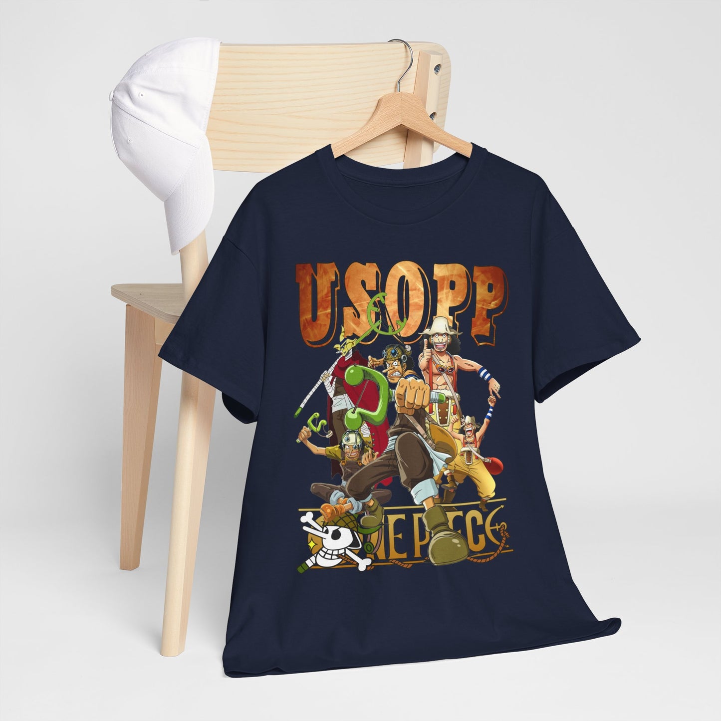 Splendid navy Usopp t-shirt artistically draped on a minimalist wooden chair, accentuated by a white cap, highlighting its stylish appeal for casual outings.