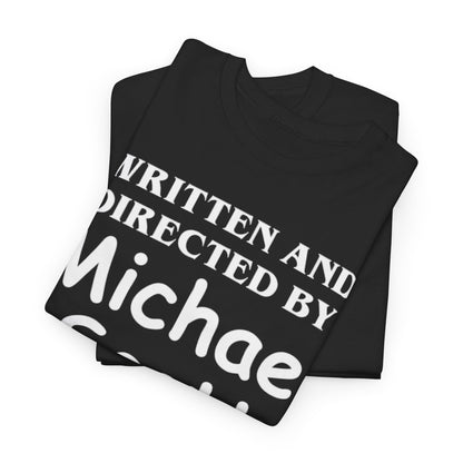 The Office Unisex Men Women Graphic Funny T Shirt Tee Urban folded neatly, highlighting the humorous inscription 'WRITTEN AND DIRECTED BY MICHAEL SCOTT' against an elegant black fabric, perfect for fans of the beloved series.