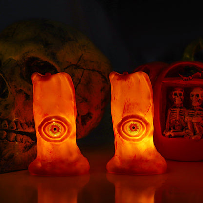 Halloween Blood Eye Lamp LED Electronic Light-emitting Candle Light displayed against a dark backdrop, illuminating two eerie candle designs that create an elegant yet terrifying ambiance.