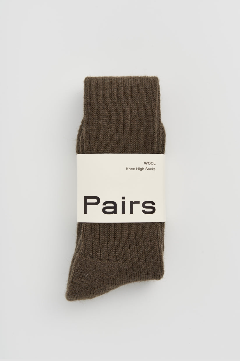 Elegant display of wool knee high socks featuring a cushioned sole, ideal for adding warmth and luxury to any outfit.