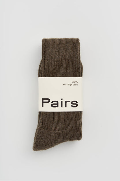 Elegant display of wool knee high socks featuring a cushioned sole, ideal for adding warmth and luxury to any outfit.