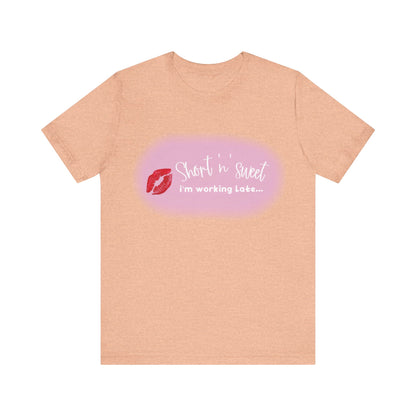 Sabrina Carpenter Inspired Unisex Short Sleeve Tee featuring a vibrant lipstick print on a light peach background, perfect for fans of style and music.