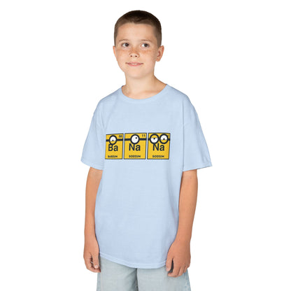 A smiling boy wearing a Minions Kids T-Shirt featuring a fun periodic table design with Barium and Sodium. This bright and humorous tee is perfect for kids who love science and the Minions, combining a vibrant look with educational elements. T Shirt, Funny, Minions.