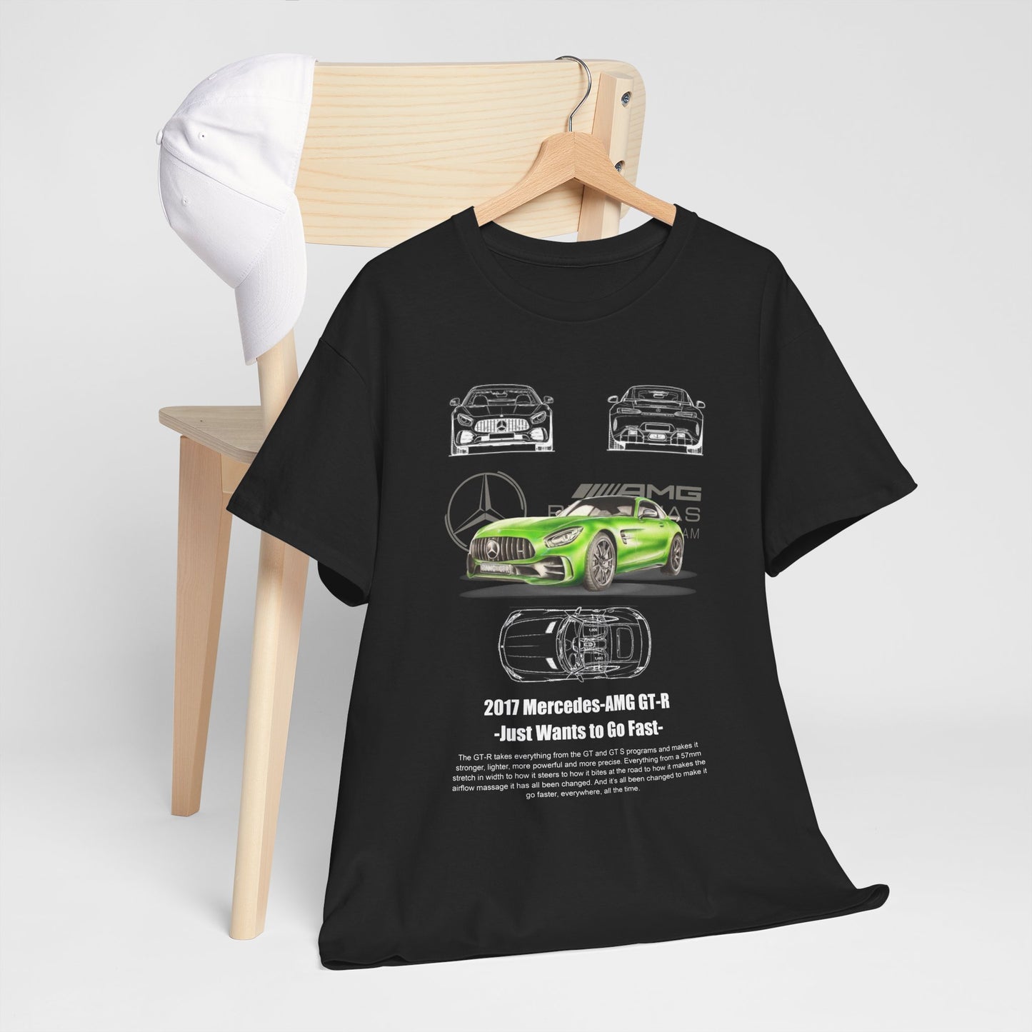 Chic black men's t-shirt draped over a wooden chair with a cap, featuring a luxurious graphic of the green Mercedes-AMG GT-R, embodying automotive passion.