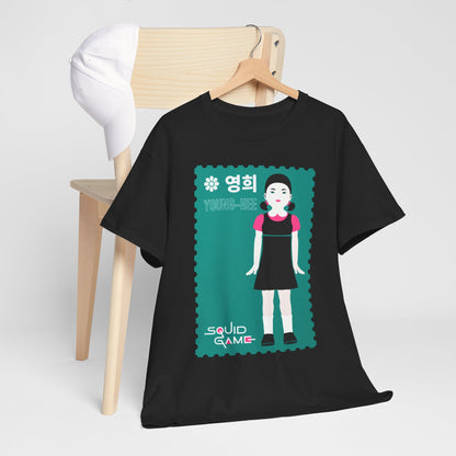Fashionable black t-shirt featuring the iconic Young-Hee graphic from Squid Game, artfully draped over a wooden chair, complemented by a white cap for a sophisticated ensemble.