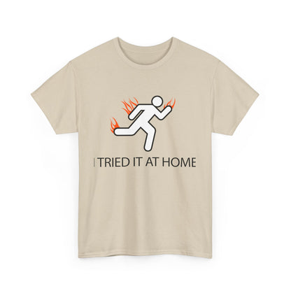 Luxurious beige men's t-shirt featuring a dynamic stick figure running with orange flames, accompanied by the bold text 'I TRIED IT AT HOME'.