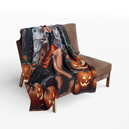Richly designed Decorative and Warm Halloween Spooky Arctic Fleece Blanket draped over a chair, featuring a glamorous witch and a festive pumpkin arrangement.