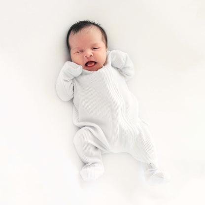 Stylish and comfortable white zip sleepsuit for infants from DreamBuy, designed with attention to detail and suitable for both play and sleep.