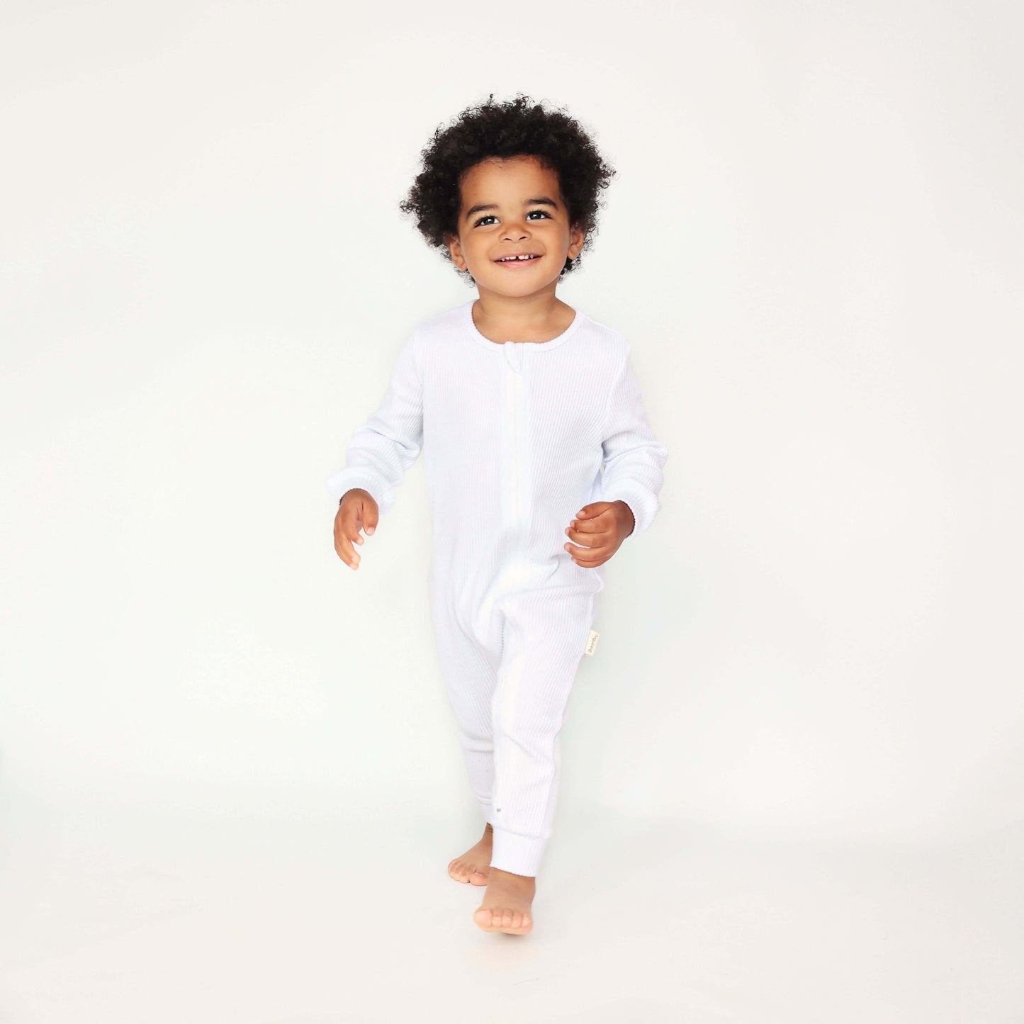 Elegant white baby sleepsuit by DreamBuy, showcasing luxurious ribbed cotton fabric, perfect as a thoughtful gift for modern parents.