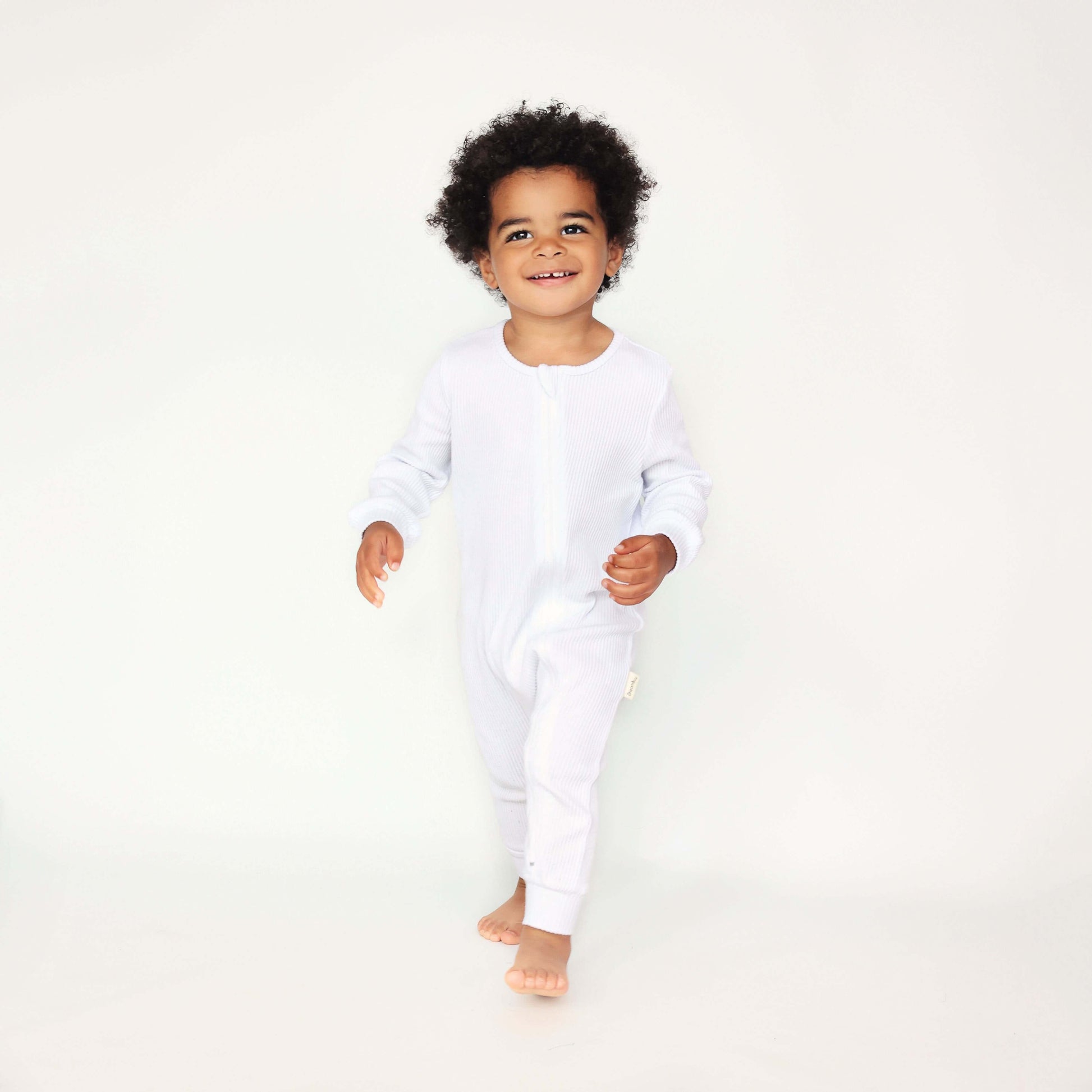 Elegant white baby sleepsuit by DreamBuy, showcasing luxurious ribbed cotton fabric, perfect as a thoughtful gift for modern parents.