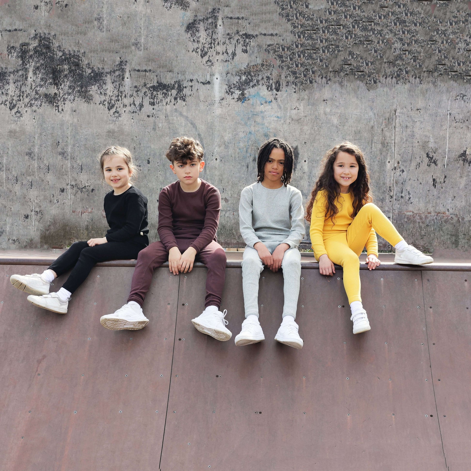 Elegant family lounging in DreamBuy's Dove Grey Matching Pyjamas, highlighting the minimalist style and soft fabric, perfect for comfort during play and sleep.