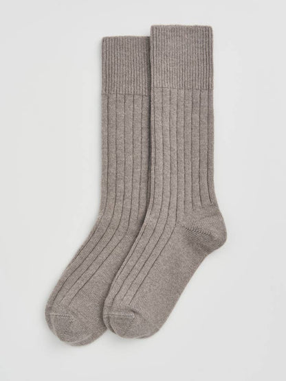 Luxury Merino bed socks in a chic setting, highlighting their temperature-regulating technology for ultimate comfort and warmth.