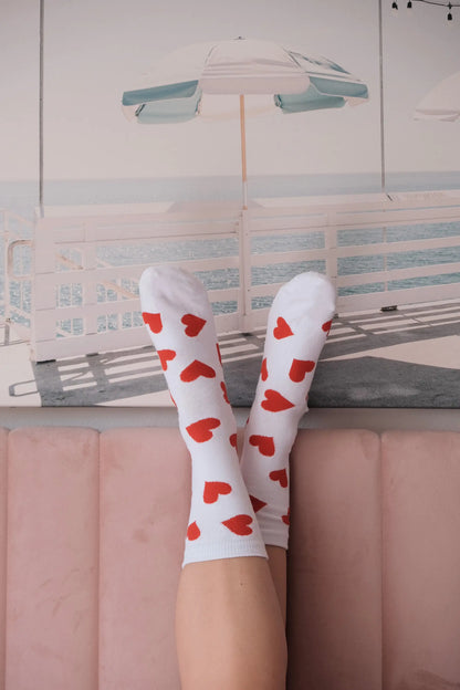 Charming Women's White Socks with Elegant Red Hearts for Stylish Comfort and Fashionable Appeal, featured in a relaxed pose, highlighting the luxurious pattern against a chic decor backdrop.