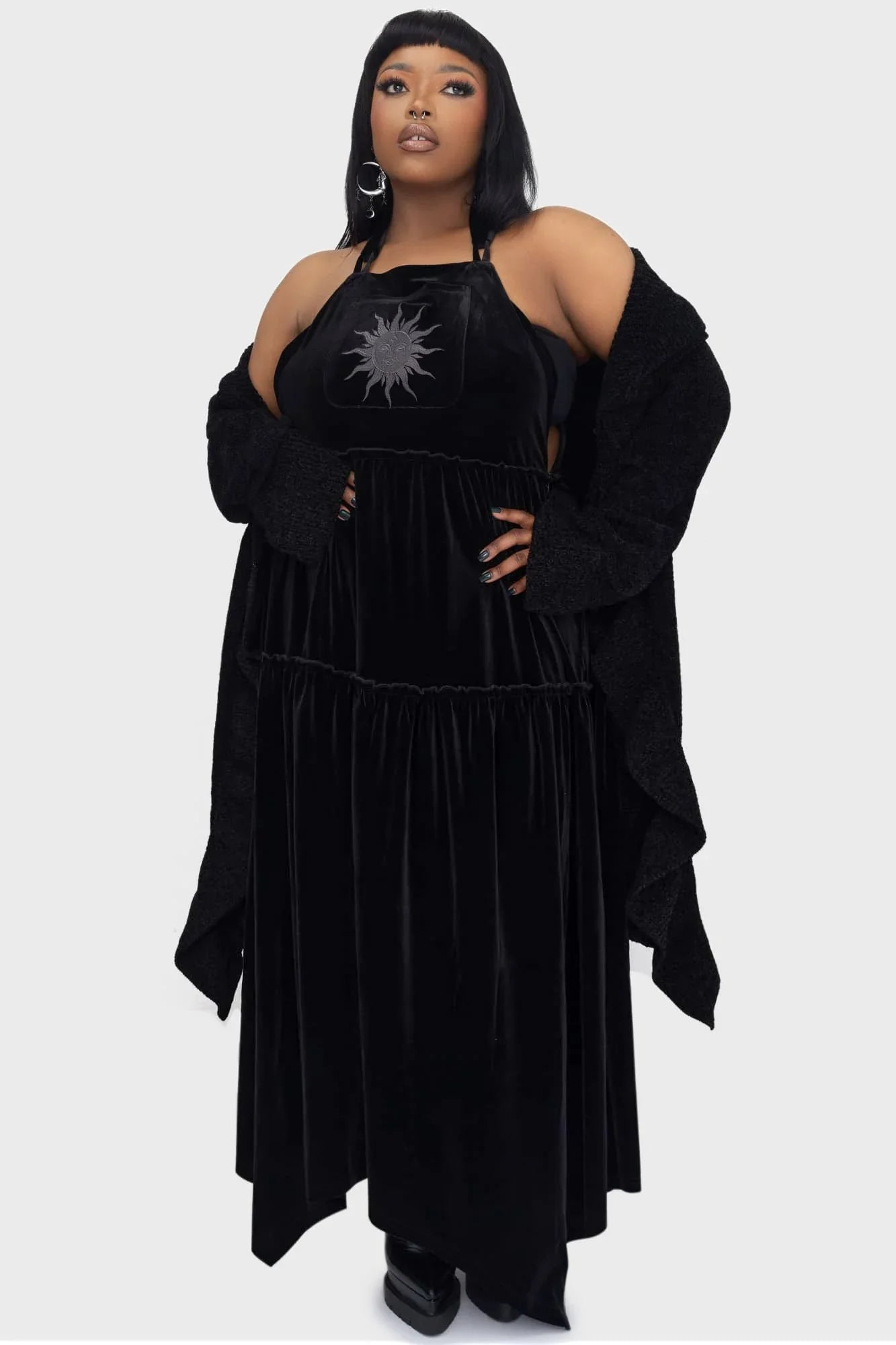 Killstar Ascended Velvet Maxi Pinafore Dress showcasing luxurious black velvet fabric and intricate sun embroidery on the front pocket, perfect for stylish layering.