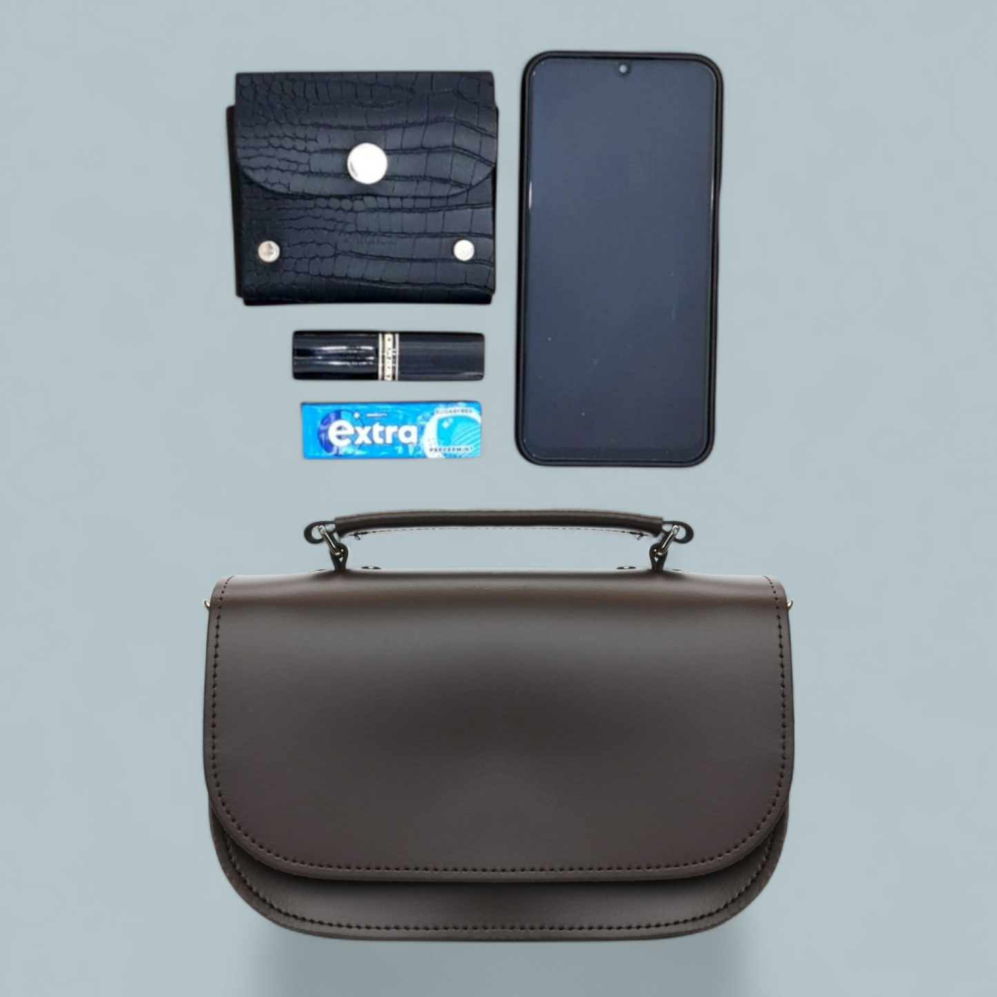 Versatile styling options of the Aura Luxury Dark Brown Leather Handbag, displayed as a chic clutch and crossbody bag, ideal for both casual and formal occasions.