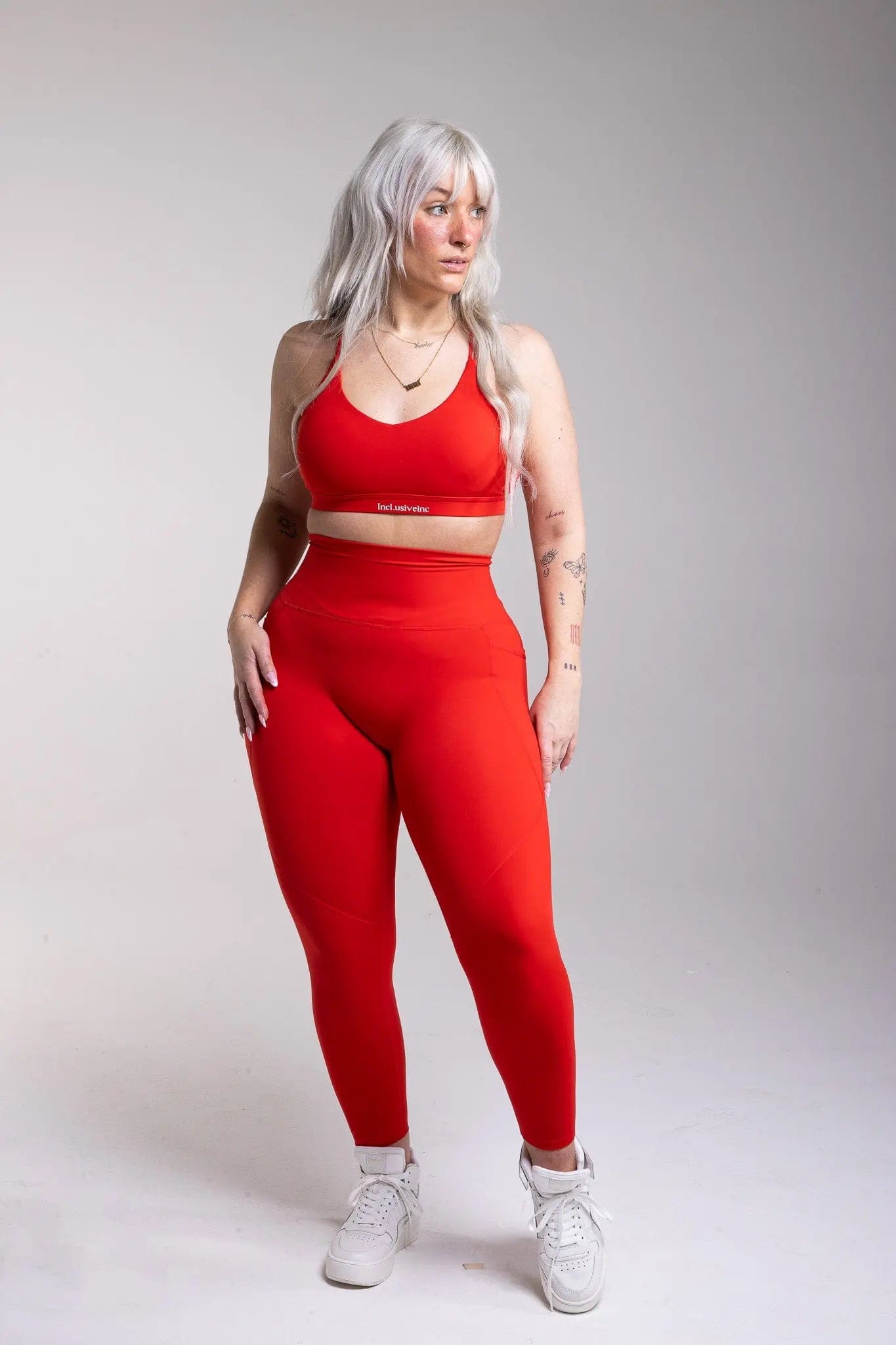 Close-up of thePremium Active red leggings by Incl.usiveinc showcasing the stretchy fabric and contouring seams for a sculpted fit.
