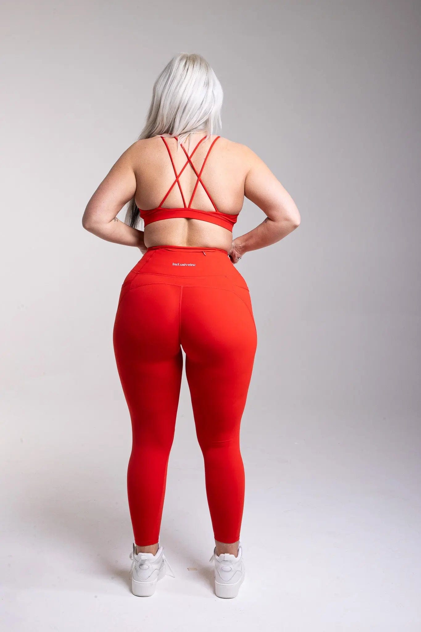 Incl.usiveinc high waist red gym leggings modelled during a workout, demonstrating their sweat-wicking and quick-drying capabilities.