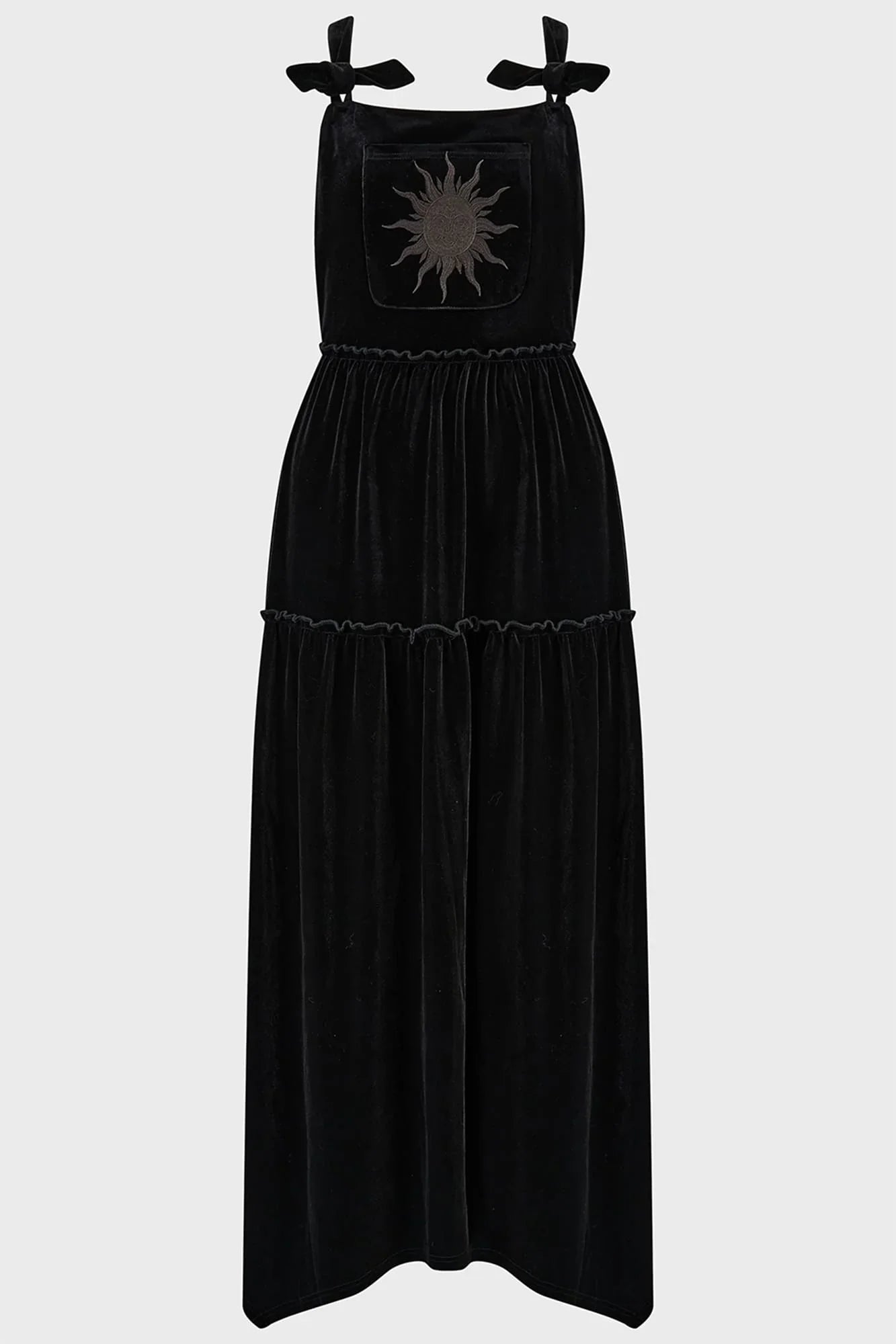 Close-up view of the black velvet fabric and intricate sun embroidery on the front pocket of the Killstar Ascended Velvet Maxi Pinafore Dress, exuding a mystical and elegant vibe.