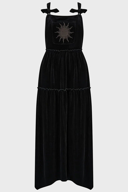 Close-up view of the black velvet fabric and intricate sun embroidery on the front pocket of the Killstar Ascended Velvet Maxi Pinafore Dress, exuding a mystical and elegant vibe.