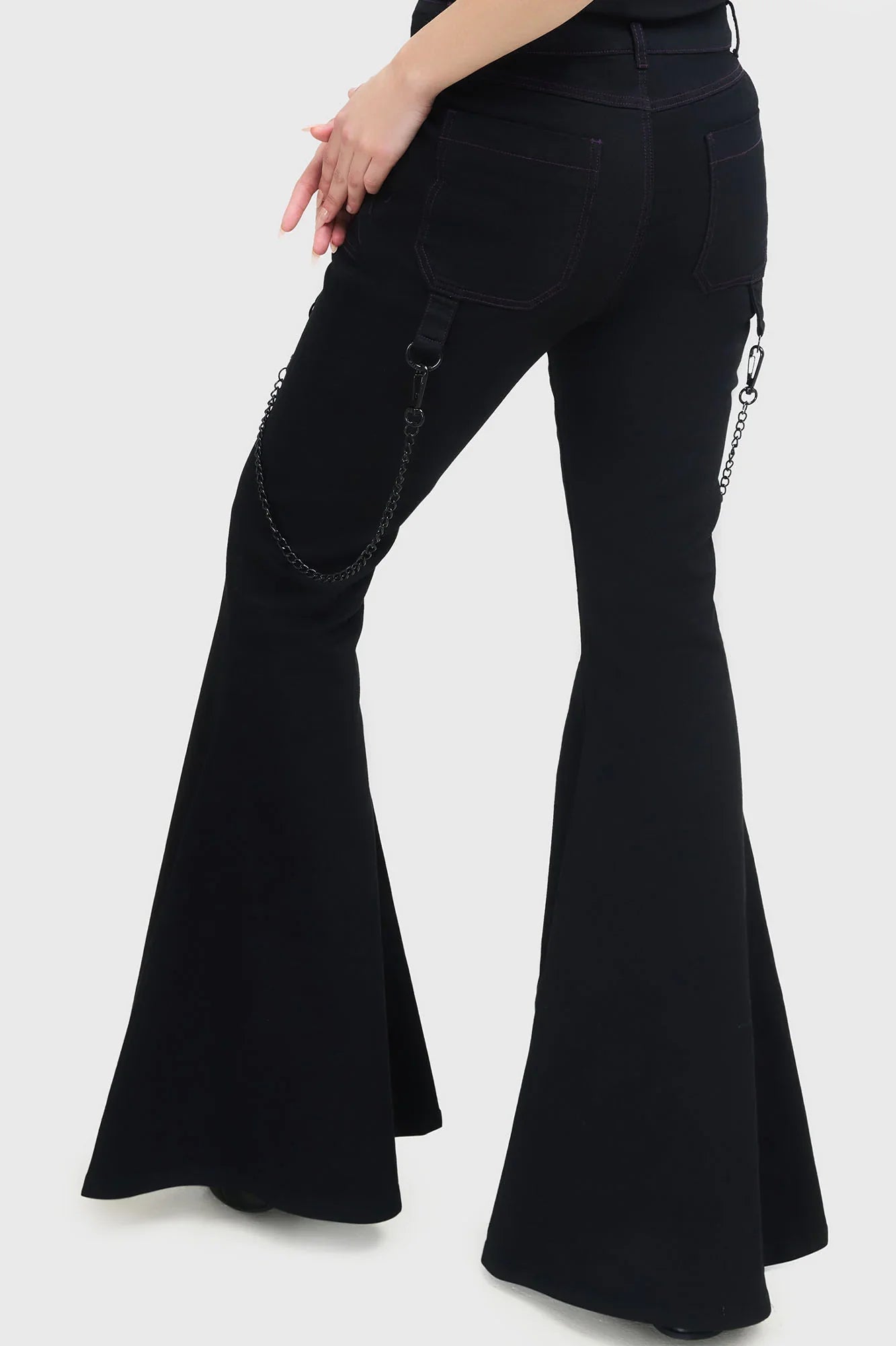 Stylish profile of the Killstar Beliala Trousers demonstrating the adjustable straps and fit-and-flare silhouette, epitomising contemporary goth fashion.